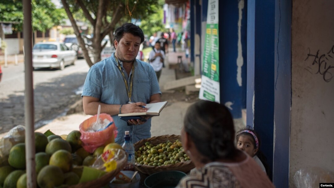 Mientras reportaba en Masaya, Nicaragua, el periodista Wilfredo Miranda conversa con una vendedora de frutas. [Cortesía]