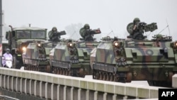 Taiwanese armored vehicles roll down a street in Kinmen on May 24, 2024. China warned on May 24 that Taiwan's leadership was pushing the self-ruled island into "a perilous situation of war and danger."