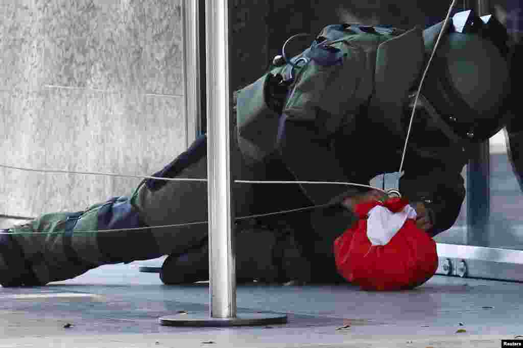 A bomb expert works on a package suspected to be a bomb, at the entrance of the Venezuela Central Bank in Caracas.