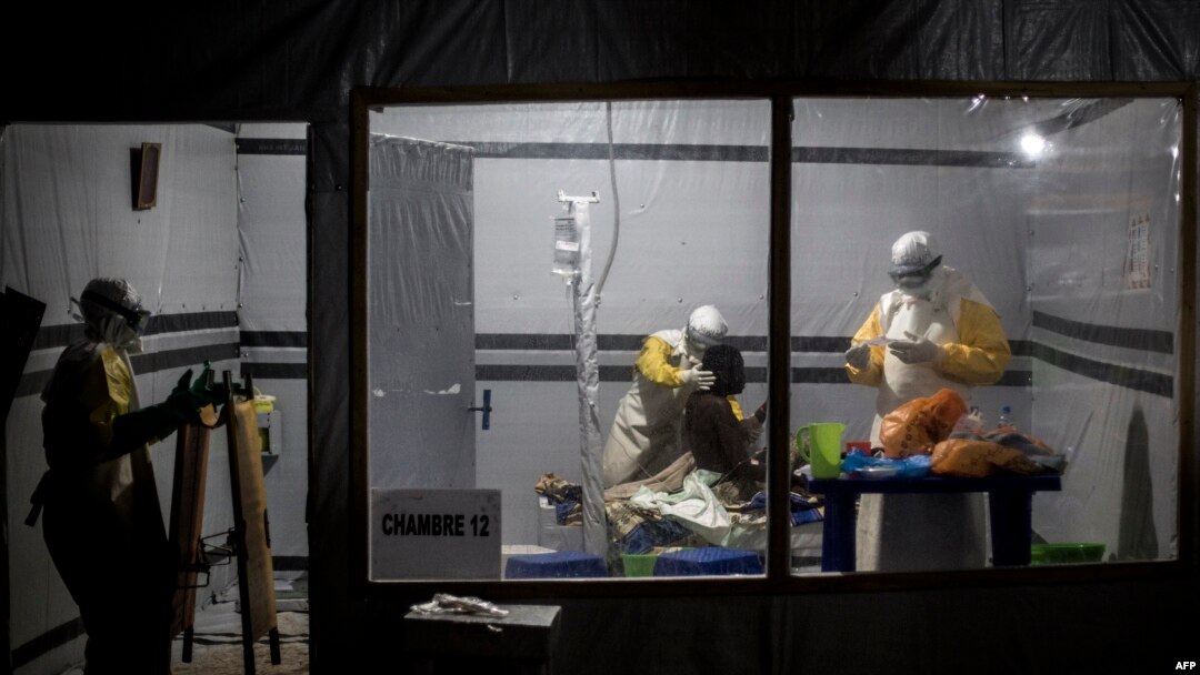 FILE - Health workers treat an unconfirmed Ebola patient, inside a MSF (Doctors Without Borders) supported Ebola Treatment Center (ETC) in Butembo, Democratic Republic of the Congo, Nov. 3, 2018. Attackers set fire to an Ebola treatment center in Katwa late Sunday.