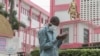 A man wears a mask while walking outside the entrance to the Yaounde General Hospital in Yaounde on March 6, 2020, as Cameroon has confirmed its first case of the COVID-19 virus.