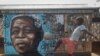 FILE - A child kicks a football in front of a mural of the country's first Black president and leader of the ruling African National Congress Nelson Mandela, in Soweto, South Africa, as the country celebrates Freedom Day, on April 27, 2024.