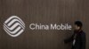 一名男子路过中国移动的标志
