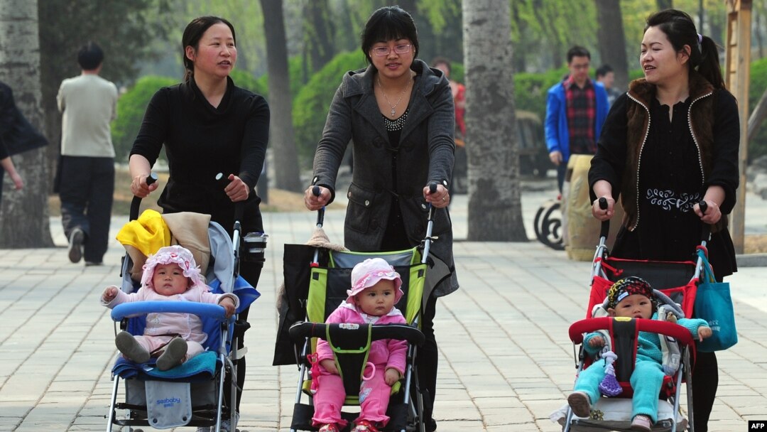 FILE - Women push babies in prams through a Beijing park during a public holiday, April 5, 2011.