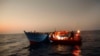 Migrants sailing in a crowded wooden boat carrying more than seven hundred migrants, are helped by members of an NGO during a rescue operation at the Mediterranean sea, about 13 miles north of Sabratha, Libya, Aug. 29, 2016. 