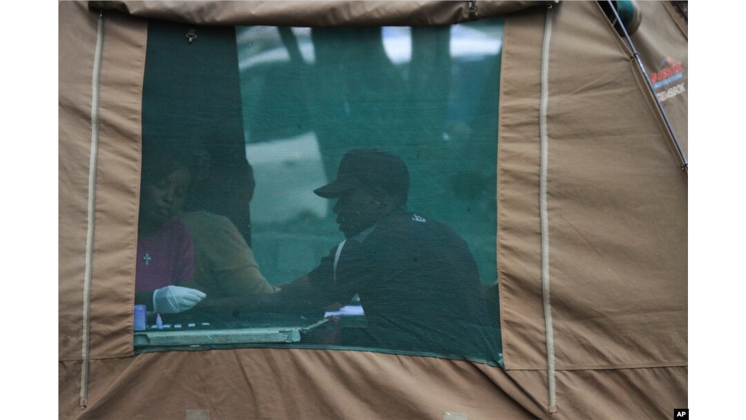 FILE - A man has his blood taken before being tested for HIV in Harare, Zimbabwe, May 9, 2014.