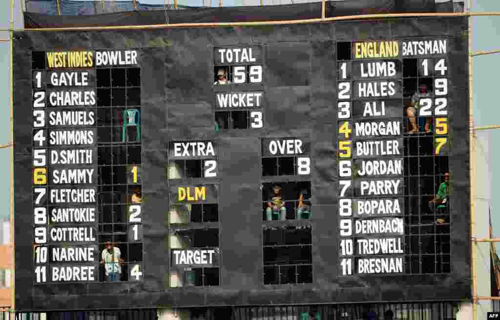 Bangladesh spectators sit inside a scoreboard as they watch the ICC World Twenty20 cricket tournament warm-up match between England and the West Indies at the Khan Shaheb Osman Ali Stadium in Fatullah on the outskirts of Dhaka.