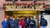 Voluntarios y observadores internacionales frente al restaurante La Cachapera Bcn, uno de los puntos de asistencia técnica durante la jornada de votación de la consulta popular en Barcelona, España, el 12 de diciembre de 2020. [Foto VOA/Júlia Riera]..