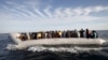 FILE - Migrants, who tried to flee to Europe, travel in a dinghy after they were stopped by Libyan coast guards and made to head to Tripoli, Sept. 29, 2015. 