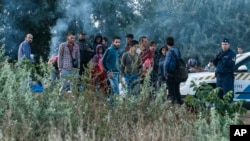 Illegal migrants are seen at the railway crossing at the border between Hungary and Serbia near Roszke, 180 kms southeast from Budapest, Hungary, Aug. 25, 2015. 