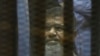 FILE - Egypt's ousted Islamist President Mohammed Morsi sits in a soundproof glass cage inside a makeshift courtroom at Egypt’s national police academy in Cairo, April 21, 2015. 