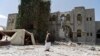 A man loyal to former Yemeni president Ali Abdullah Saleh stands guard at Saleh's house destroyed by a Saudi-led airstrike in Sanaa, Yemen, Sunday, May 10, 2015.