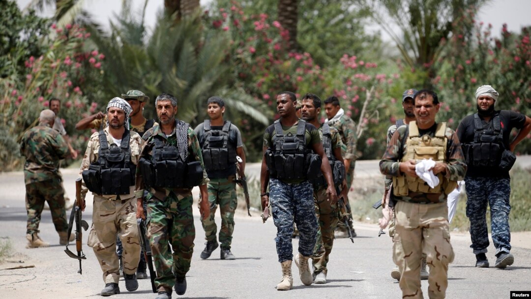 Shi'ite fighters hold their weapons as they gather near Fallujah, Iraq, June 4, 2016. 