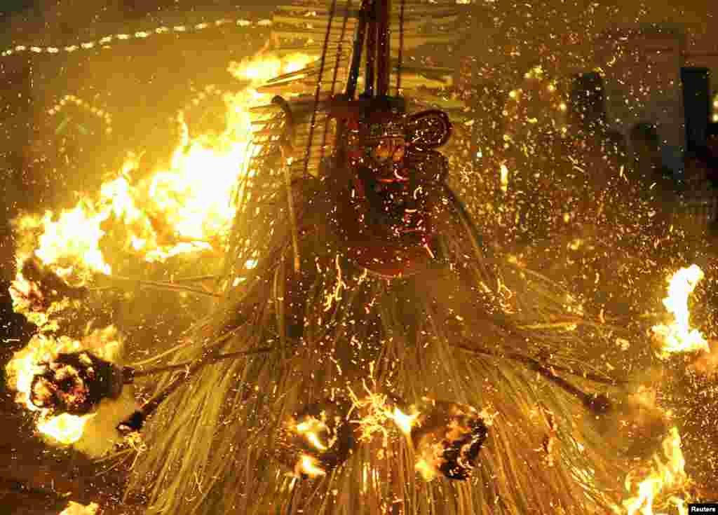 An artist dressed as Hindu god Kandakarnan performs a ceremonial dance with fire during the Theyyam ritual in Somwarpet town in the southern Indian state of Karnataka.