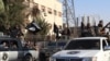 An image made available by Jihadist media outlet Welayat Raqa on June 30, 2014, allegedly shows a member of the IS (Islamic state) militant group parading in a street in the northern rebel-held Syrian city of Raqqa.