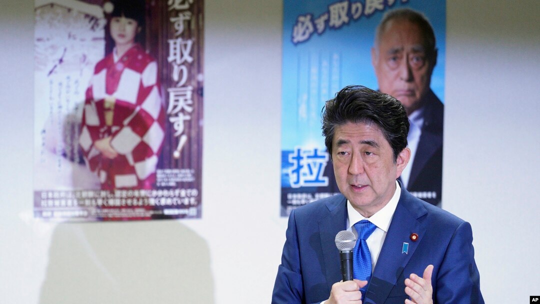 FILE - Japanese Prime Minister Shinzo Abe delivers remarks to families of Japanese citizens abducted by North Korea, in front of abduction awareness posters during an event in Tokyo, Japan, April 22, 2018.