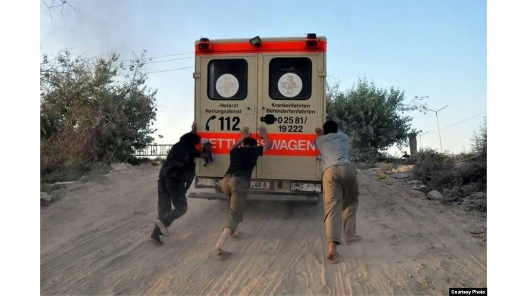 FILE - Abdul-Rahman (Peter) Kassig (center) helps push an ambulance up a hill during his time working with SERA. Photo taken near Deir Ezzor, August 2013. (Copyright, with permission to use from Kassig family)