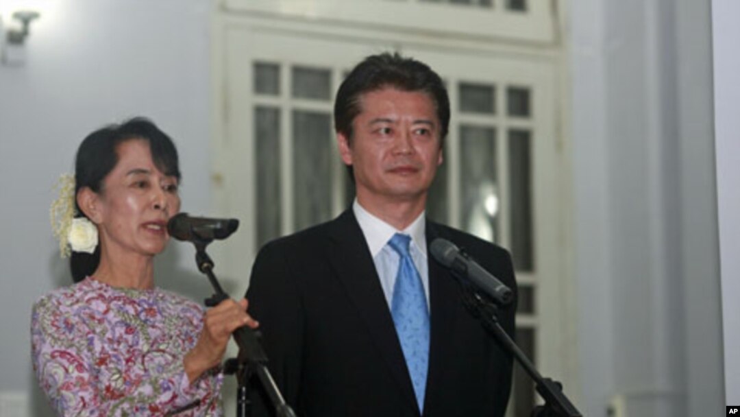 Myanmar's Pro-Democracy Leader Aung San Suu Kyi (L) talks to reporters after meeting with Japan's Foreign Minister Koichiro Gemba at her home in Rangoon, Burma, December 26, 2011.