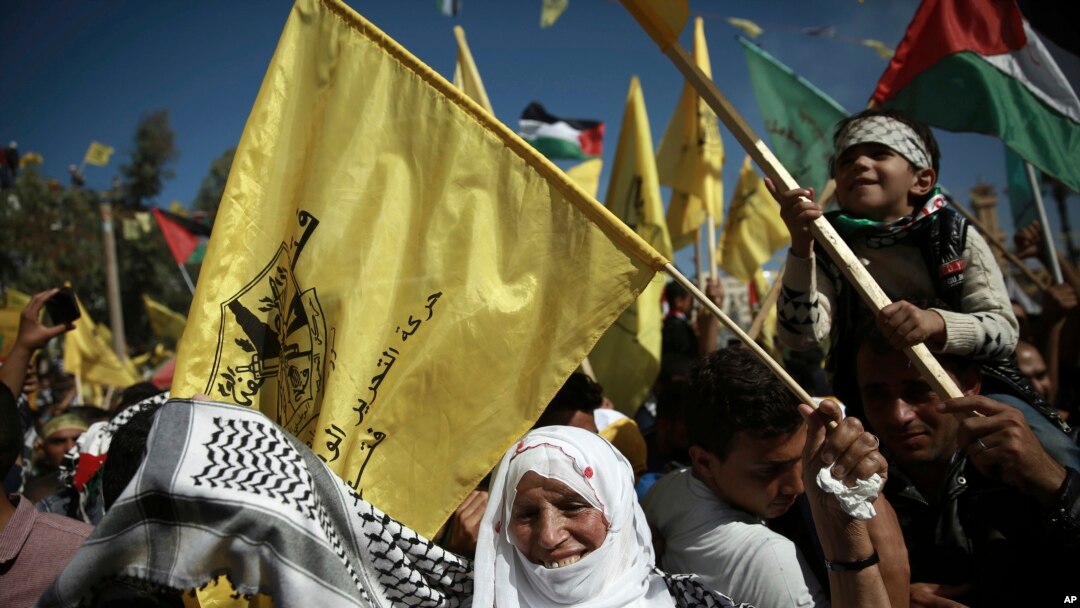 Palestinians wave national and yellow Fatah movement flags during a rally marking the 13th anniversary of the death of Fatah founder and Palestinian Authority leader Yasser Arafat, in Gaza City, Saturday, Nov. 11, 2017.