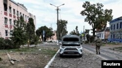 Binh sĩ Ukraine tuần tra gần các tòa nhà bị hư hại trong cuộc giao tranh giữa lực lượng Ukraine và Nga tại thị trấn Sudzha do quân đội Ukraine kiểm soát, ở vùng Kursk, Nga, vào ngày 16/8/2024.