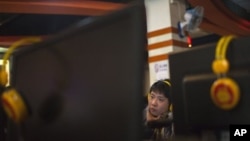 A man uses a computer at an Internet cafe in Beijing, Friday, Dec. 28, 2012. China is increasing already tight controls on Internet use and electronic publishing after embarrassing online reports about official abuses.