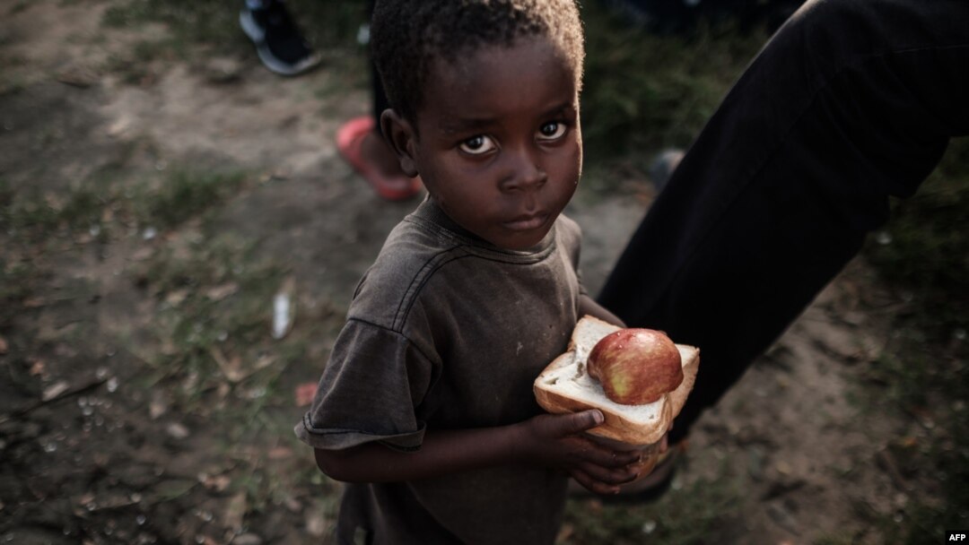 Lokacin da wani yaro ya karbo abinci a wani sansani a Mozambique, ranar 27 ga watan Maris, 2019.

