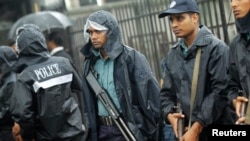 Police officers stand guard in front of the gate of International Crimes Tribunal (ICT) before a verdict against Bangladesh Jamaat-e-Islami chief Motiur Rahman Nizami in Dhaka, June 24, 2014.