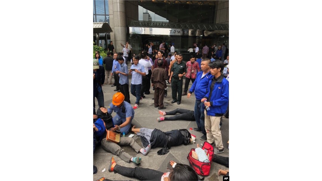 An Indonesian worker attends one of evacuated victims after a structure inside the Jakarta Stock Exchange tower collapsed in Jakarta, Indonesia, Monday, Jan. 15, 2018.