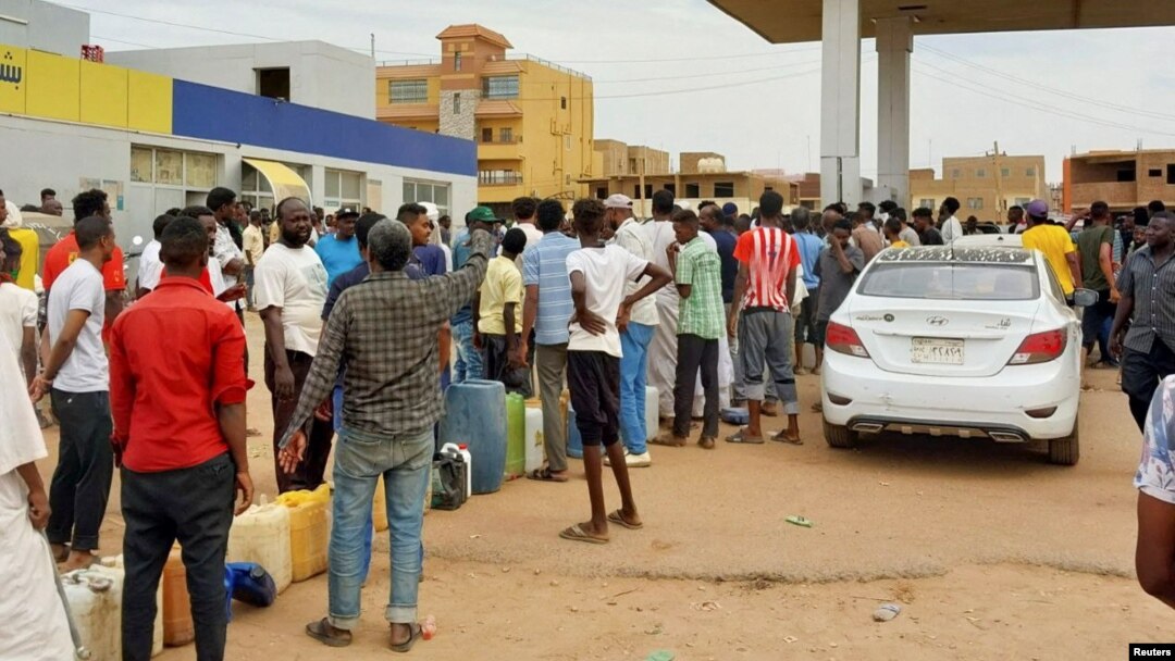 People gather to get fuel at a station, as clashes between the paramilitary Rapid Support Forces and the army continue, in south Khartoum locality, Sudan, April 30, 2023.