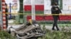 La policía camina cerca de los restos de un coche bomba que explotó cerca de una estación de policía en Padilla, Cauca, Colombia, el domingo 6 de febrero de 2022.
