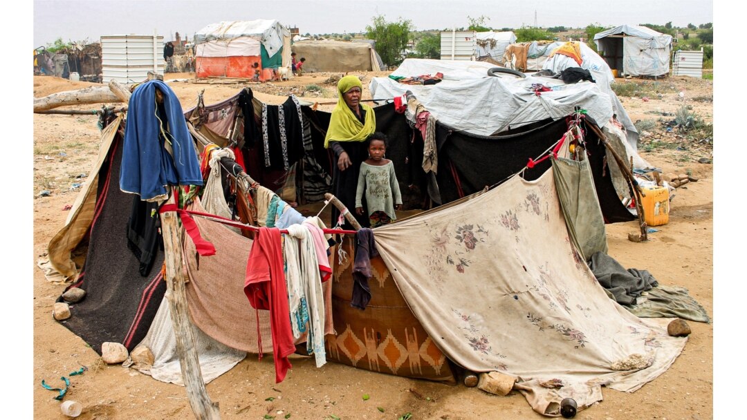 FILE - A woman and child sit together in an enclosure made from fabrics at a make-shift camp for displaced Yemenis in the northern Hajjah province, Dec. 16, 2019.