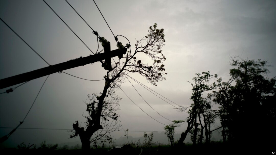 FILE - In this Oct. 16, 2017 file photo, power lines lay broken after the passage of Hurricane Maria in Dorado, Puerto Rico. Federal officials said on Jan. 8 2018, that efforts to fully restore power to Puerto Rico should get a boost with more work crews and more equipment arriving in upcoming weeks. 